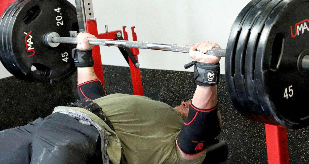 Man bench pressing heavy weight in a gym, showcasing push exercise technique.