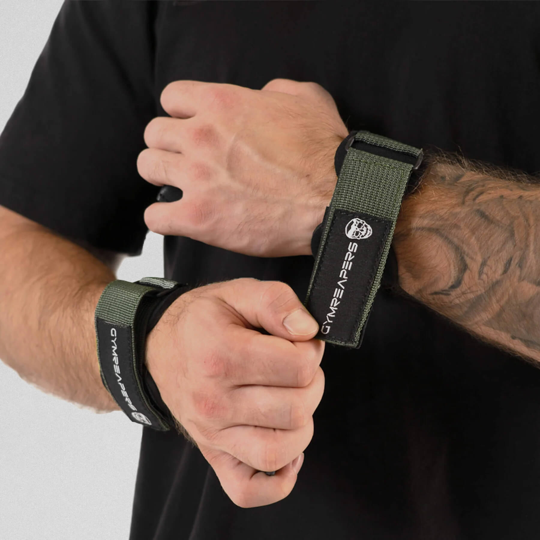 Gymreapers athlete attaching grips onto wrist, while the other one has it on already.